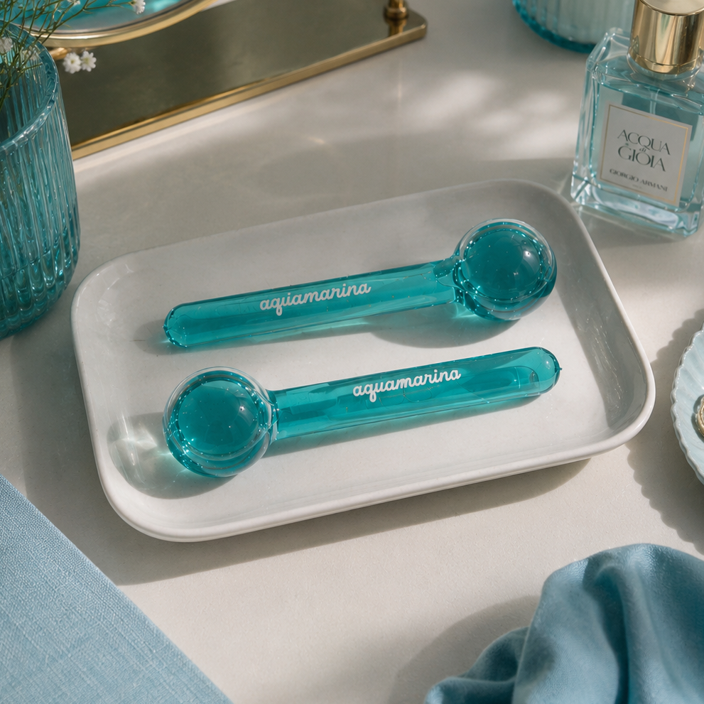 Two turquoise ice globes on a white tray with a decorative background.